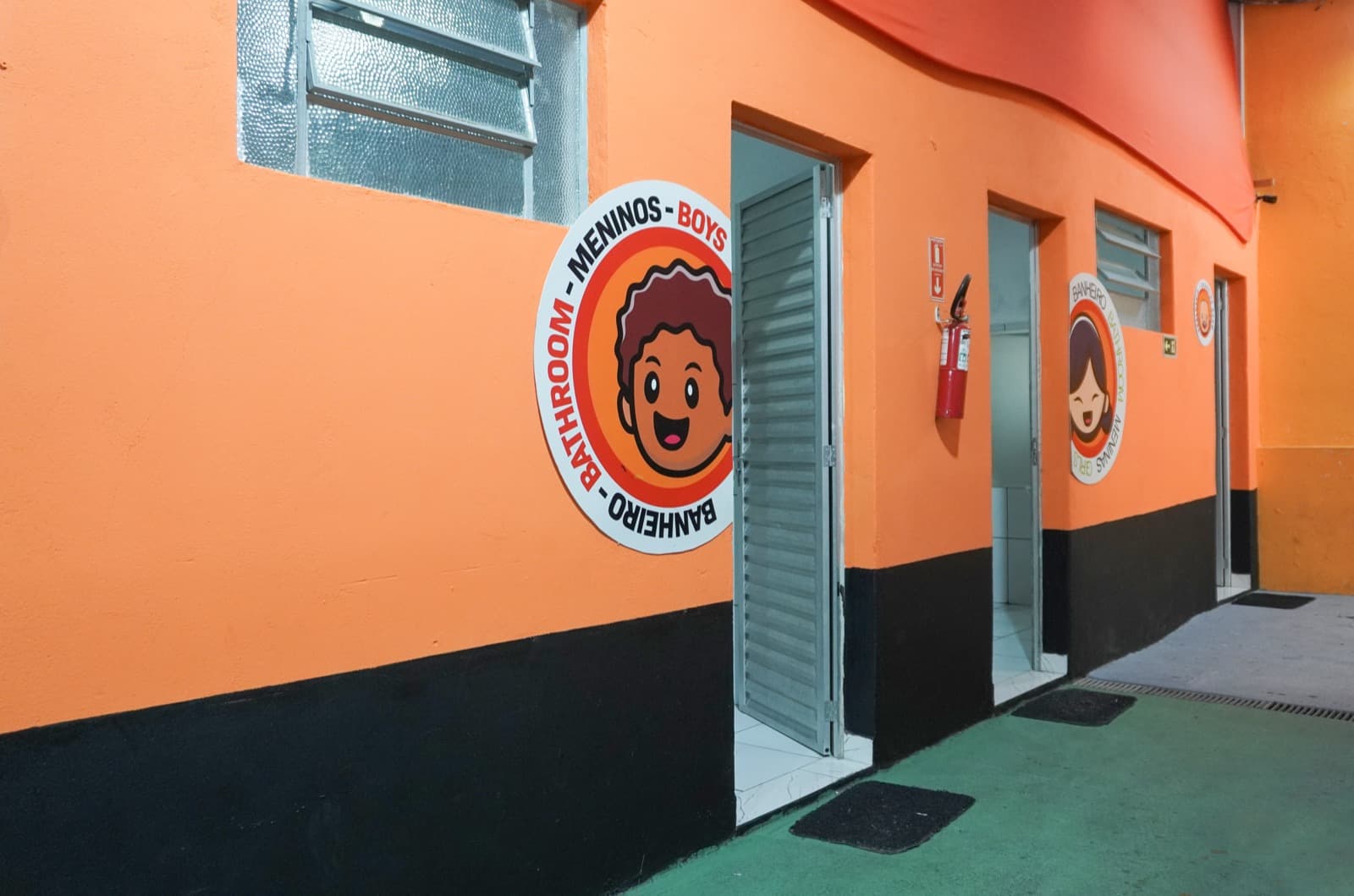 Banheiros temáticos para meninos e meninas com placas ilustradas bilíngues