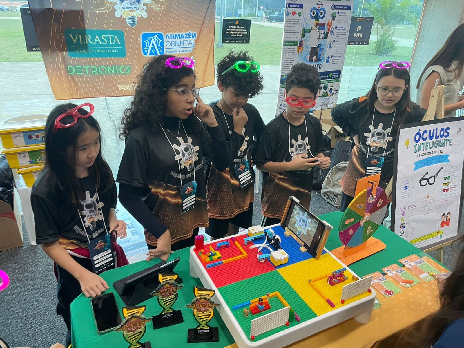 Alunos do IDEIA apresentando projeto de robótica com troféus conquistados na Jornada Tecnológica WAL